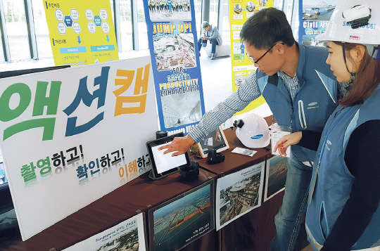 삼성물산 직원이 현장 근로자의 작업모에 액션캠을 부착해 업무 중 안전관련 사항을 실시간으로 점검하는 사례를 시연하고 있다. 삼성물산 제공